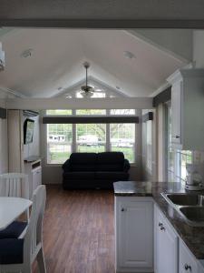 cocina y sala de estar con sofá negro en Circle M Camping Resort Loft Park Model 18, en Wabank