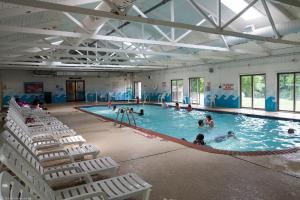 a large swimming pool with chairs and people in it at Circle M Camping Resort Loft Park Model 18 in Wabank