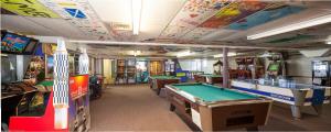 a room with several arcade games and pool tables at Circle M Camping Resort Loft Park Model in Wabank +5 photos