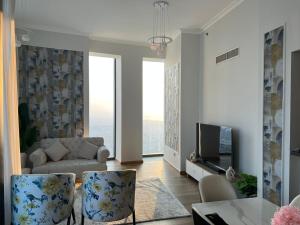 Una sala de estar con un sofá y un televisor. en Private Room in an 3BR High Rise with Burj Khalifa and Fountain Views, en Dubái