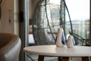 a table with two vases sitting on top of it at Sunlit Serenity Lakefront Apartment in Frankton +23 photos