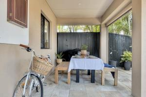 a patio with a table and a bike on a patio at Beautiful Family House with Pool and BBQ in Gold Coast