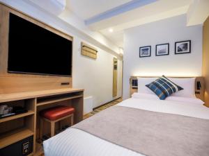 a bedroom with a large television and a bed at FLEXSTAY INN Higashi Jujo in Tokyo +14 photos