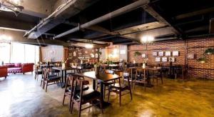 a restaurant with tables and chairs and a brick wall at James Joyce Coffetel Xi'an Laochenggen Hongmiaopo Metro Station in Xi'an