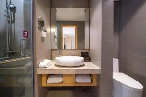 a bathroom with a sink and a toilet and a mirror at Yitel Shenyang Sanhao Street Shengjing Hospital in Shenyang +201 photos