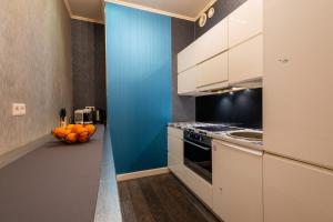 a kitchen with white cabinets and a blue wall at PlatinumTowers! PRIVAT JACCUZI! PANORAMIC CITY VIEW from 14 Floor! LOGGIA! PARKING! 66m2! 2 ROOMS in Warsaw