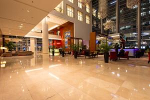 a large lobby with tables and chairs in a building at PlatinumTowers! PRIVAT JACCUZI! PANORAMIC CITY VIEW from 14 Floor! LOGGIA! PARKING! 66m2! 2 ROOMS in Warsaw