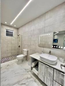 a bathroom with a sink and a toilet at FYV Beach Villas in San Juan