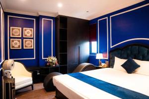- une chambre avec des murs bleus, un lit et une chaise dans l'établissement Lumi Sky Hotel - by BAY LUXURY, à Hà Ðông 6 autres photos