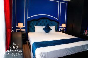 - une chambre avec un lit bleu et blanc et 2 lampes dans l'établissement Lumi Sky Hotel - by BAY LUXURY, à Hà Ðông