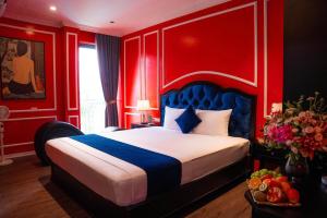 une chambre rouge avec un lit à tête de lit bleue dans l'établissement Lumi Sky Hotel - by BAY LUXURY, à Hà Ðông