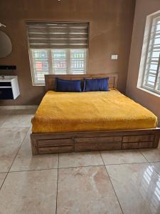 a bedroom with a large bed with a yellow bedspread at Hamai nisha villa in Ambalavayal