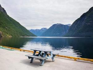 Una mesa de picnic junto a un lago con montañas. en Modern Retreat in Klitgards-By Traum, en Nibe