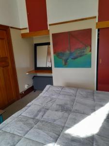 a bedroom with a bed and a painting on the wall at Great place to stay in Gisborne