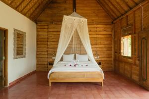 un dormitorio con una cama con dosel en Green vanilla kabin, en Silebeng