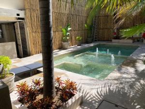 a swimming pool with a palm tree in a yard at Ashly Boulevard in Acapulco