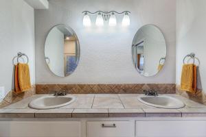 two sinks in a bathroom with two mirrors at The Golden Hour Getaway Pool Lake Views Games in Abbeyville +43 photos