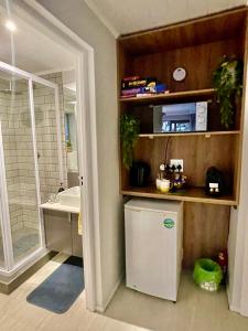 a bathroom with a sink and a small refrigerator at OceanBreeze50 Stylish Garden Route Stay in Central Mossel Bay in Mossel Bay