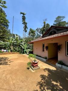 een huis met een vuilnisbelt ervoor bij River stream Nest homestay in Madikeri