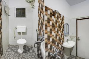 a bathroom with a toilet and a sink at Hotel O Kogilu Bus Terminal Formerly Peaceful Stay in Yelahanka