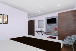 ラーンチーにあるSuper Townhouse Rauniyar City Centre Ratu Roadの大きなベッドと椅子のある寝室