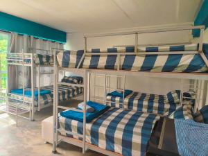 three bunk beds in a room with blue at DS Sport Hostel in Ko Lanta