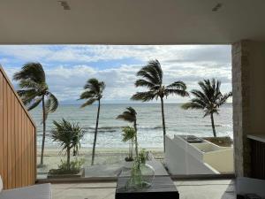 a room with a view of the ocean and palm trees at Luxury by the sea unmatched comfort in Bucerías