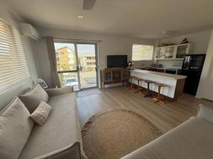 Beachside Getaway in Sunny Palm Beach في غولد كوست: غرفة معيشة مع أريكة ومطبخ +6 صور