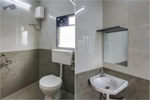 a bathroom with a toilet and a sink and a mirror at FabHotel Golden Heights in Hinjewadi