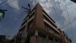 ein hohes Gebäude mit Stromleitungen darüber in der Unterkunft Union Rooms in Coimbatore + 8 Fotos