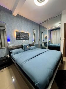 a bedroom with a large bed with blue sheets at Beautiful apartment in front of Playce Palmeraie Faya in Abidjan