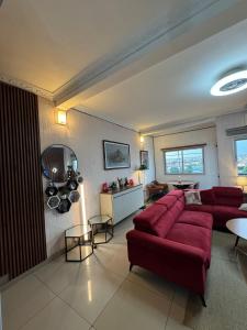 a living room with a red couch and a table at Beautiful apartment in front of Playce Palmeraie Faya in Abidjan
