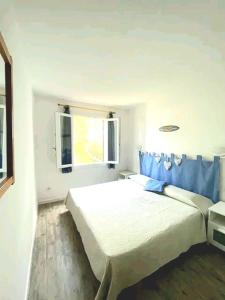 a bedroom with a white bed and a window at Solisla in Arenal d'en Castell