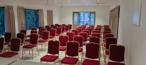 a row of chairs in a room with red chairs at WOW Naturefull Resorts in Yercaud +29 photos