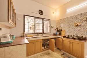チェンナイにあるHostel Gandhiの大きなキッチン(木製キャビネット、シンク付) +19枚の写真
