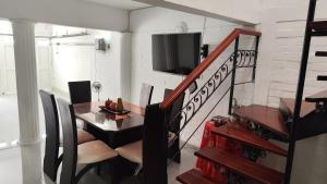 une salle à manger avec une table et une télévision dans l'établissement Hermosa casa en Cartago V, à Cartago 9 autres photos