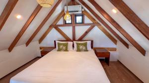 a bedroom with a bed in a attic at Kupu Kupu Villas Mentawai in Katiet