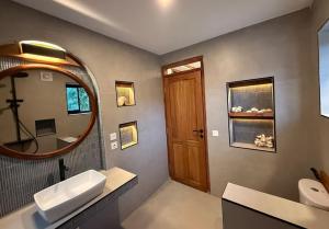 a bathroom with a sink and a mirror at Kupu Kupu Villas Mentawai in Katiet