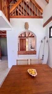 a wooden table with a plate of bananas on it at Kupu Kupu Villas Mentawai in Katiet +23 photos