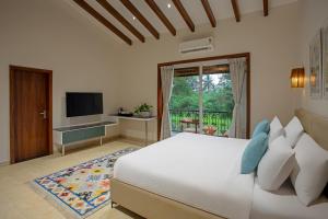 モージムにあるLamrin Morjim Goaの大きなベッドとテレビのある寝室