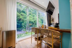 a kitchen with a table and chairs and a large window at J Boutique Hotel El Nido Managed by H Hospitality Group in El Nido