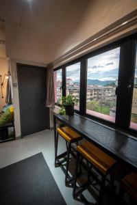 a room with a table and two chairs and a window at The Brownstone Hostel & Space in Ipoh