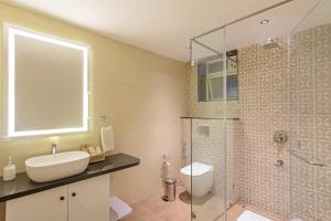a bathroom with a toilet and a sink and a shower at Lamrin Morjim Goa in Morjim +3 photos