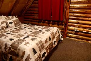 Un dormitorio con una cama en una cabaña de troncos en Log Cabin at Rainier Lodge (0.4 miles from entrance), en Ashford