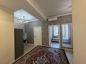 a living room with a large rug and a bedroom at Bright & Airy Apartment in Central Bishkek in Bishkek +4 photos