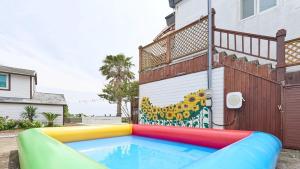 a swimming pool in front of a house at Seogwipo From Jeju in Kama-ri