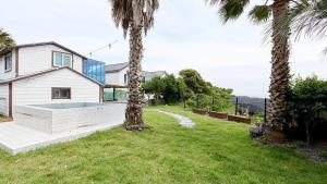 a house with a swimming pool in a yard at Seogwipo From Jeju in Kama-ri
