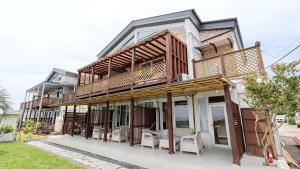 a building with a balcony with chairs on it at Seogwipo From Jeju in Kama-ri