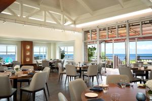a restaurant with tables and chairs with the ocean in the background at Grand Hyatt Tampa Bay in Tampa