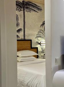 een slaapkamer met een bed met palmbomen aan de muur bij A chic apartment by Afra Paje in Paje